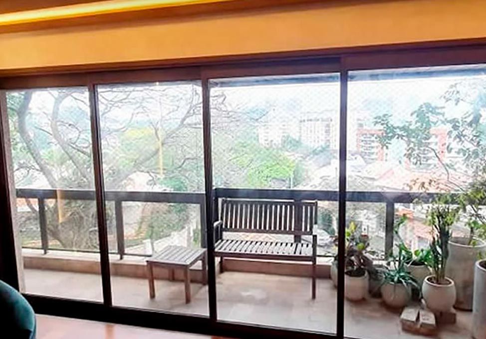 Janela acústica de correr instalada em varanda de apartamento, com vista para a cidade