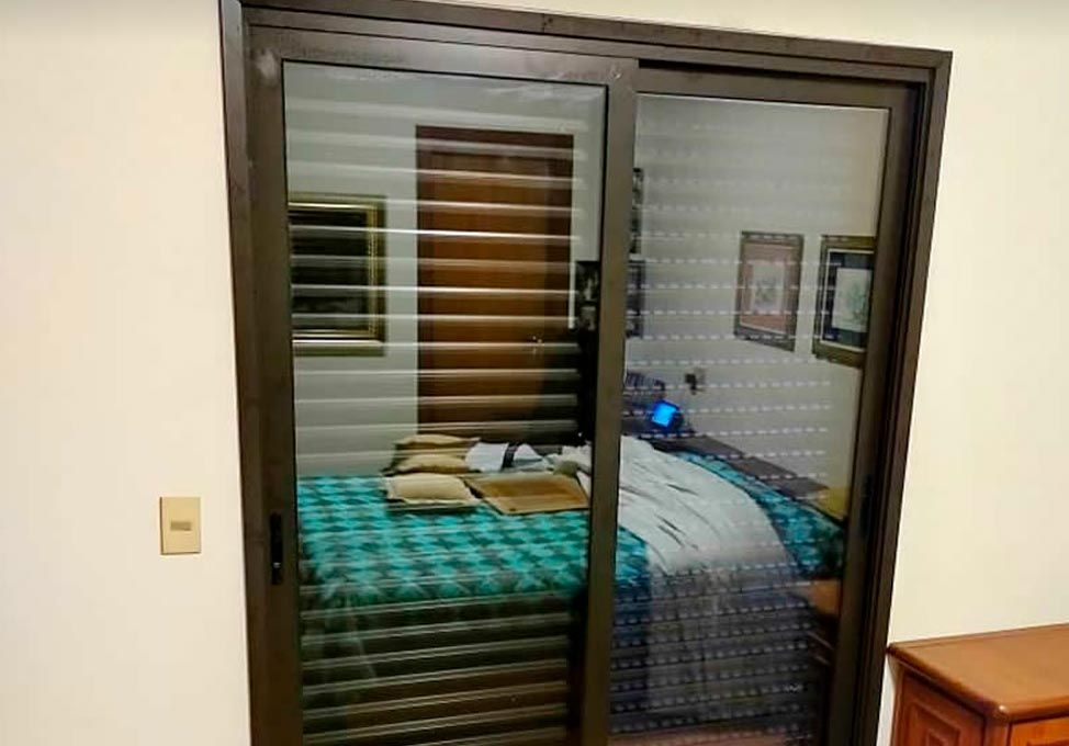 Porta de correr acústica emoldurando a vista para um quarto com cama de casal