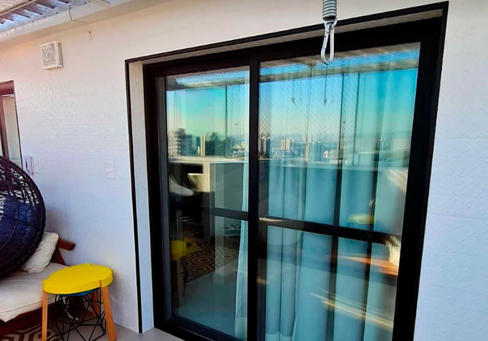 Porta acústica de correr instalada em varanda, com vista panorâmica da cidade